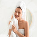 Happy woman drying face with soft face towel