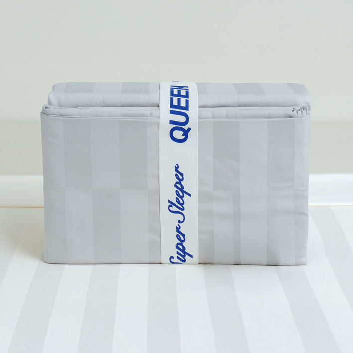 A folded light gray sheet set with subtle stripes is wrapped in a Super Sleeper Pro® Bed Sheet Organiser Band labeled “Super Sleeper Pro QUEEN”—a smart storage solution from Super Sleeper Pro (2 pack).