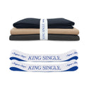 Three folded sheets in navy, beige, and charcoal are stacked with a white band labeled "King Single." In front, two Super Sleeper Pro organiser bands labeled "Super Sleeper King Single" provide a clever sheet storage solution. Product: TEST broken variant os.