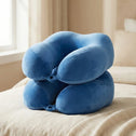 Blue memory foam travel neck pillow on bed with soft plush cover