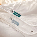 Two Super Sleeper Pro Quilt 365™ All Seasons quilts are stacked, showing a green Medium and blue Light label. Both offer clean, soft, and adjustable warmth for comfort all year round.