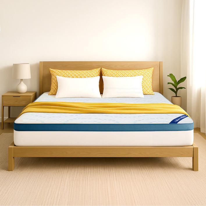 A bright, minimal bedroom featuring a neatly made bed with a light wood frame, yellow accents, and the Super Sleeper Pro [Super King] Straight 2 Sleep® Mattress Topper with Cooling Technology + FREE Pillows. A lamp and plant sit on the nightstand.