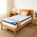 A neatly made twin bed with a light wood frame features a Super Sleeper Pro [Single] Straight 2 Sleep® Mattress Topper with Cooling Technology and free pillows. Nearby, a bedside table holds a lamp and plant, with neutral walls and white curtains.