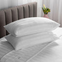 Resting atop the smooth, white bedding are a pair of pillows