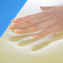 A hand presses into the yellow memory foam of the Super Sleeper Pro [King Single] Straight 2 Sleep® Mattress Topper with Cooling Technology + FREE Pillows, leaving an imprint and highlighting superior comfort and mattress renewal.