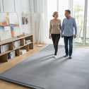 Couple walking on a gray tatami floor mat, demonstrating a soft and supportive floor tatami mat.