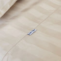 Close-up of a beige striped Royal Deluxe Imperial Dream Sheets™ Cotton Sateen 1200TC 4pc set by Super Sleeper Pro, featuring a small fabric tag and organiser bands—luxurious, silky-smooth bedding in a Buy 1 Get 1 FREE offer.
