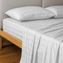 A neatly made bed features Super Sleeper Pro’s Royal Deluxe Imperial Dream Sheets™ Cotton Sateen 1200TC 4pc Set, with two matching pillows and a light wood frame, creating an inviting luxury look—plus get free organiser bands.