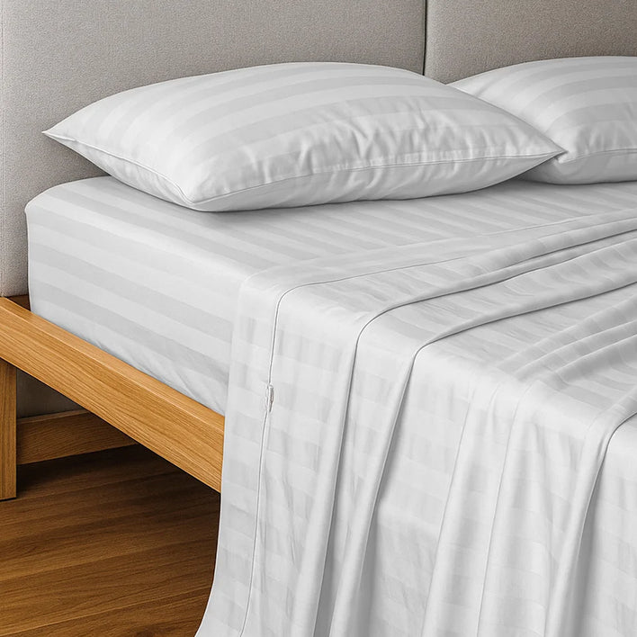 A neatly made bed features Super Sleeper Pro’s Royal Deluxe Imperial Dream Sheets™ Cotton Sateen 1200TC 4pc Set, with two matching pillows and a light wood frame, creating an inviting luxury look—plus get free organiser bands.