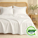 A neatly made bed features Super Sleeper Pro Buy 1 Get 1 FREE: Royal Deluxe Imperial Dream Sheets™ Cotton Sateen 1200TC 4pc Set + Free Organiser Bands. Two pillows rest against a rattan headboard; a table with a vase and grass is nearby. Awarded Winner 2026.