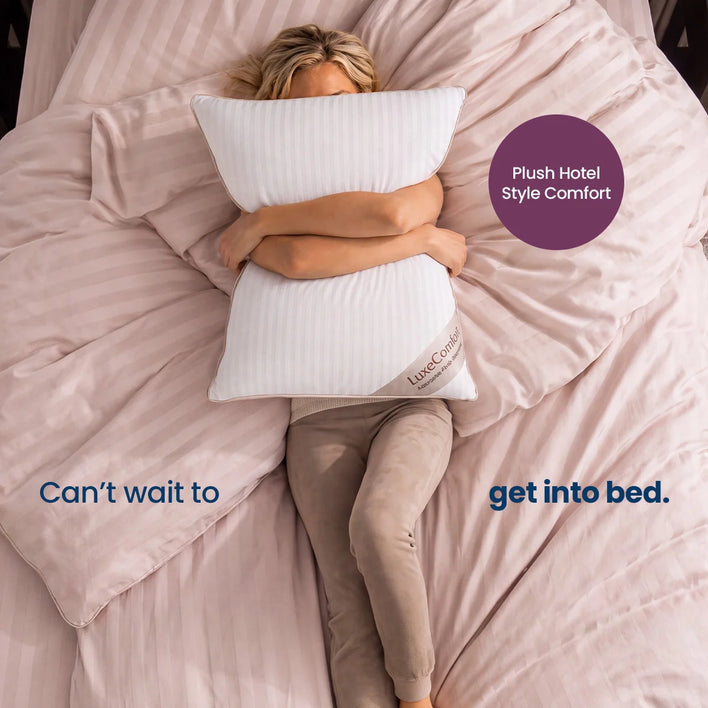 A woman lying on a bed with blush pink bedding, hugging a white ribbed pillow. Text overlays read 'Can't wait to get into bed.