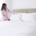 Woman arranging Marshmellow hotel pillows on bed showing plush hotel-style loft and support