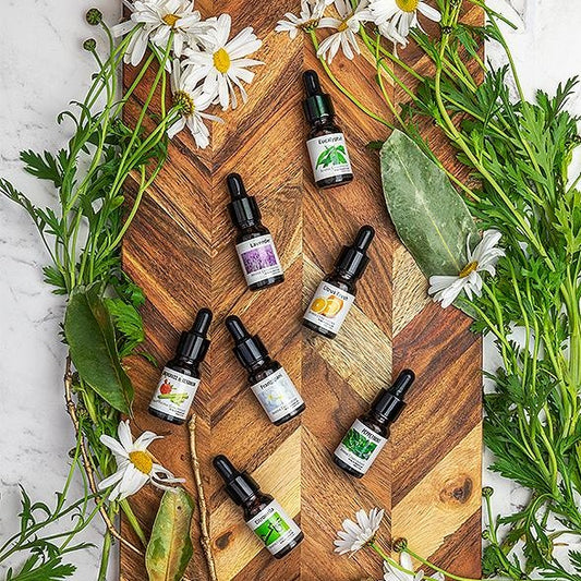 An array of essential aroma oils neatly placed on a wooden board.