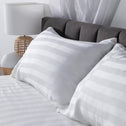 Two soft, white, cotton pillows perfectly aligned next to each other.