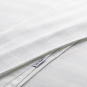 A close up of white, hotel-quality, Weave bedsheets outlining the Super Sleeper Pro branding,