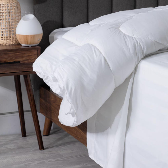 A bed in which, two pillows are accompanied by a quilt cover that has been neatly folded over them.