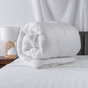 On a comfortable bed, there is a high-quality quilt cover that is exceptionally soft and neatly rolled.