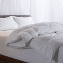 A quilt cover neatly folded over a bed including two pillows.