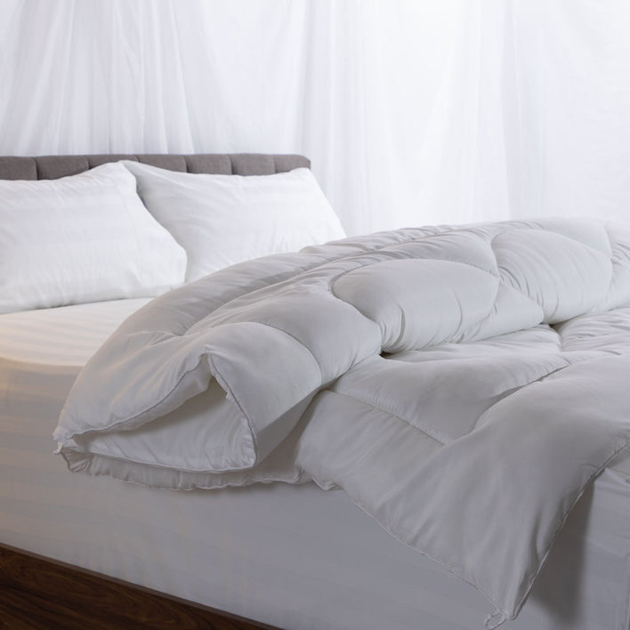 A quilt cover neatly folded over a bed including two pillows.