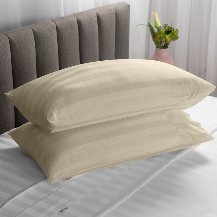 Two soft pillows neatly stacked on top of each other in a warm beige colour.