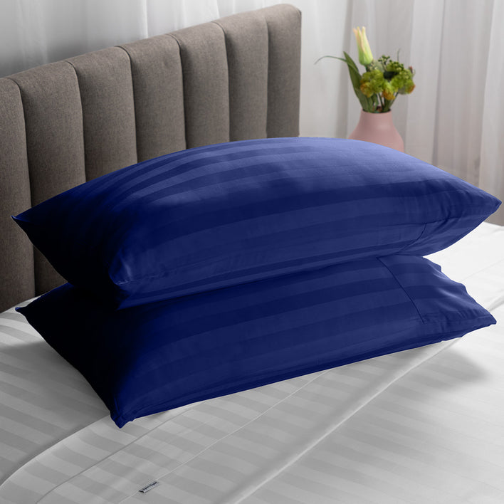 Two soft pillows neatly stacked on top of each other in a navy blue colour.