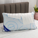 A soft memory foam pillow placed on a bed with two soft white pillowcases draped over it..