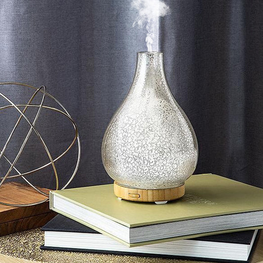 A glass diffuser placed on a pile of books.
