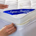 A person’s hands are shown: one hand pulls the zipper on a white Replacement Cover For Super Sleeper Pro® Wave Topper, branded "Super Sleeper Pro", while the other presses down on the quilted bamboo viscose cover.